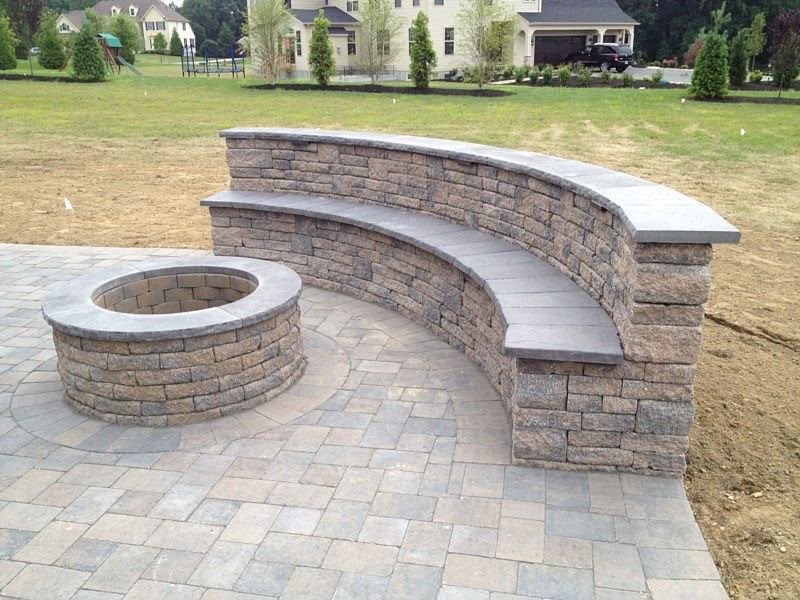 Curved stone fire pit with built-in bench