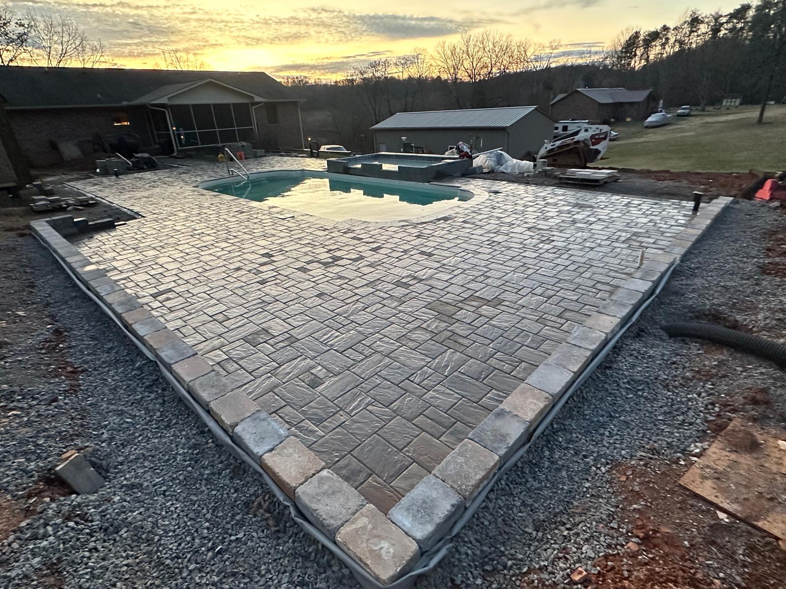 Herringbone paver pool patio at sunset