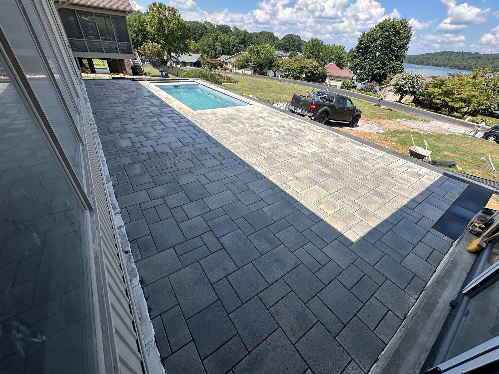 Two-tone paver pool deck with lake view
